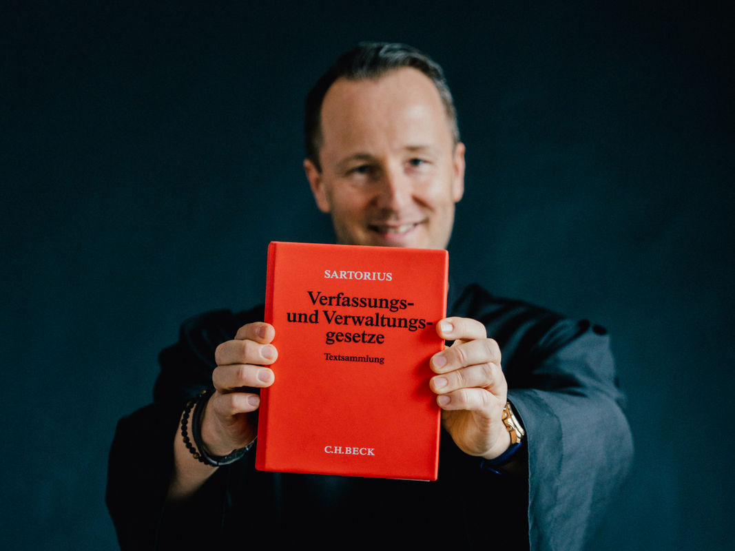 Hände eines Immobilienmediators halten ein geöffnetes Buch in einer professionellen Szene.